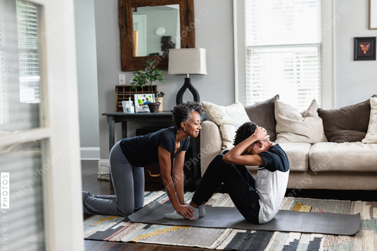 Black mom helps son do sit-ups at home, stay fit, health and wellness