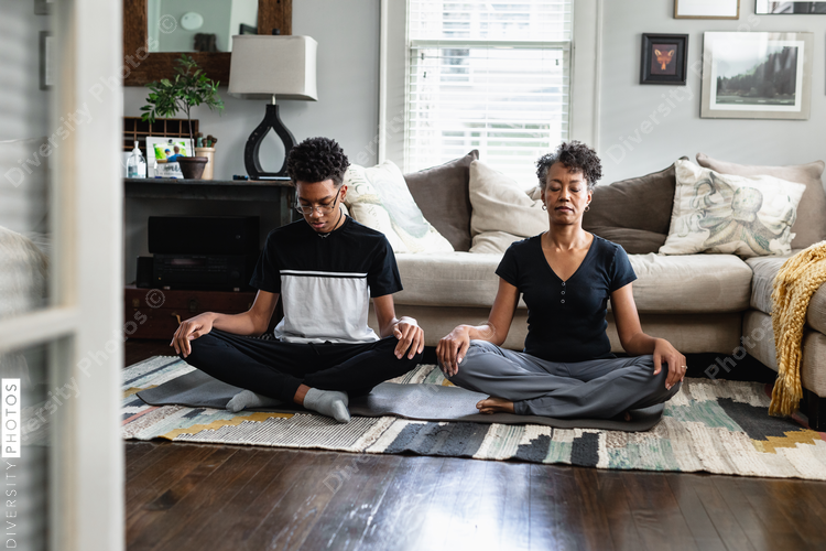 Black mother and son doing meditation and breathing exercises, peaceful, relaxation