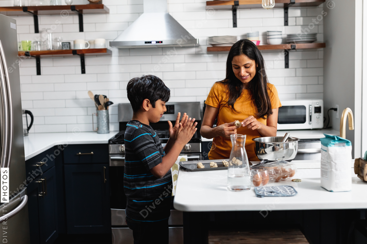 Indian mother and son baking homemade cookies