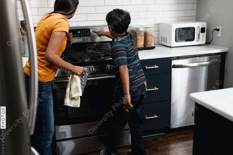 Indian boy turns on light to watch cookies bake in oven
