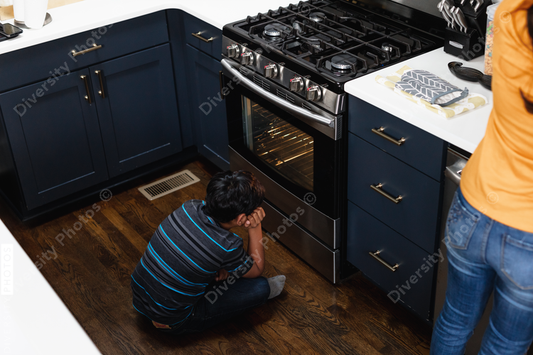 Young Indian boy waits for homemade cookies to bake in the oven