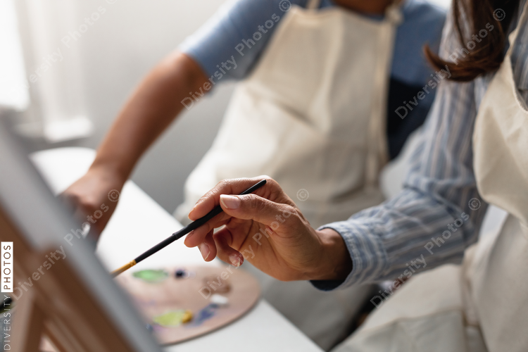 DIverse mother and son painting at home, kid activities