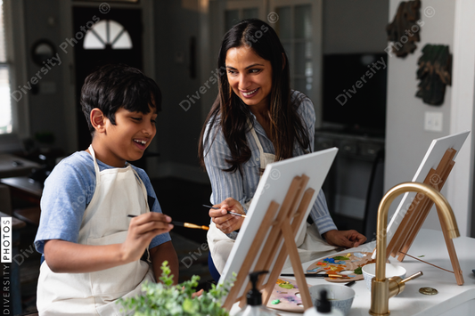 Indian mother and son laughing, painting at home, do-it-yourself