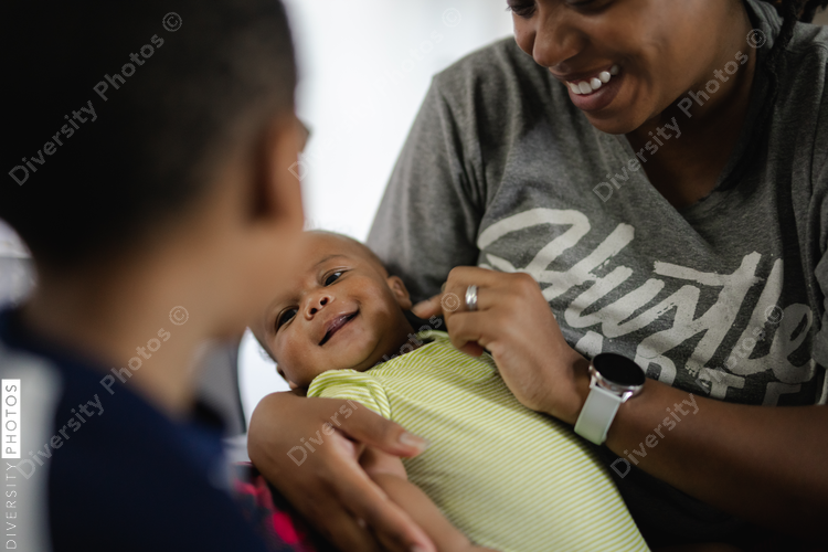 Newborn smiling in moms arms, African American