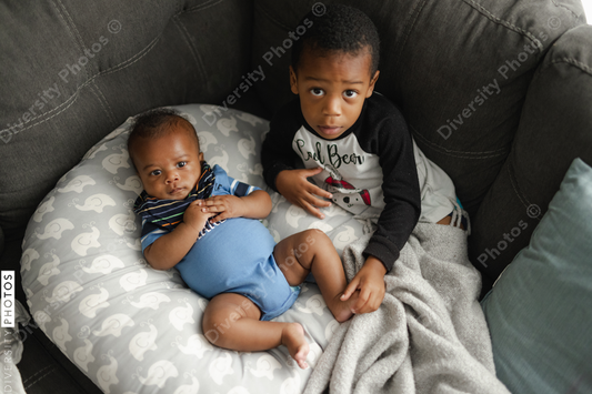 Black boys, siblings, sitting and laying on sofa