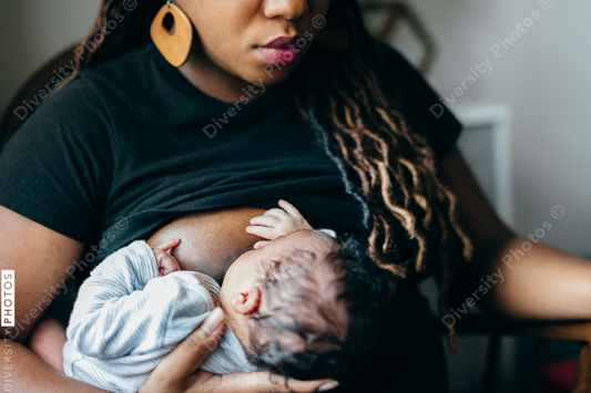 Black woman breastfeeding child at home