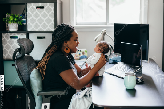 Black mother works from home with a newborn child
