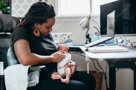 Black mother works from home with a newborn child