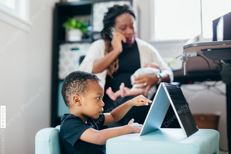 Black mother working from home with children, professional businesswoman