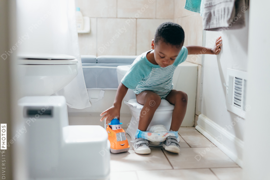 Black boy, potty training time at home, playing with toy truck