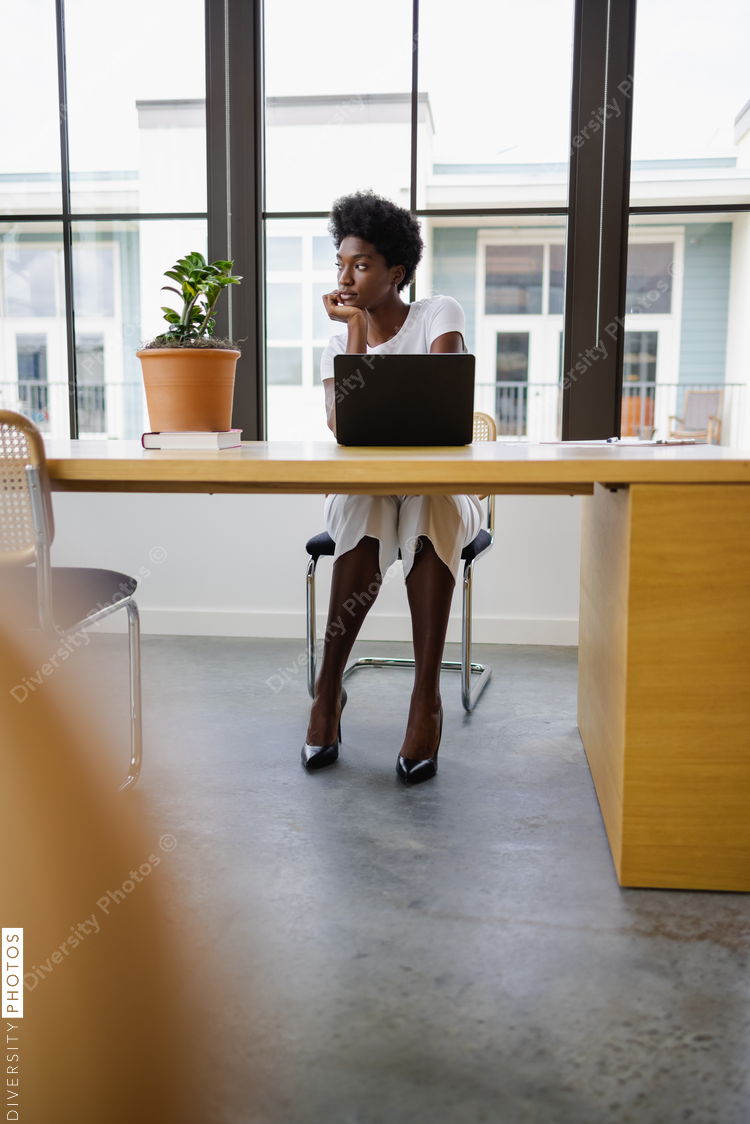 Thoughtful Black Business woman using laptop in office