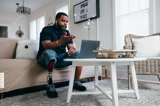 Black man with prosthetic leg working from home on laptop