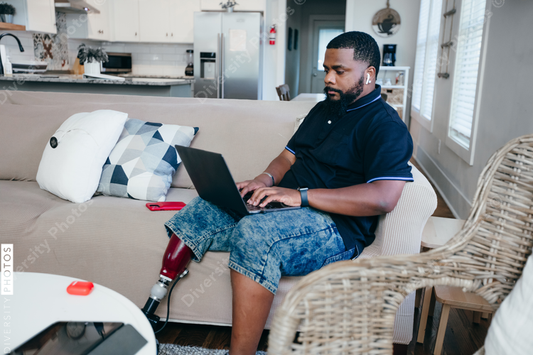 African American man working from home on laptop, disability 