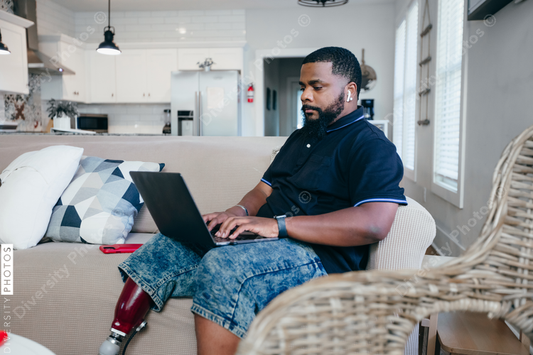 African American man working from home on laptop, disability 
