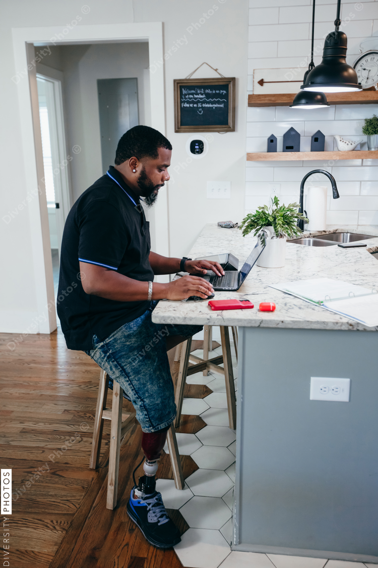 Man with disability working from home on laptop