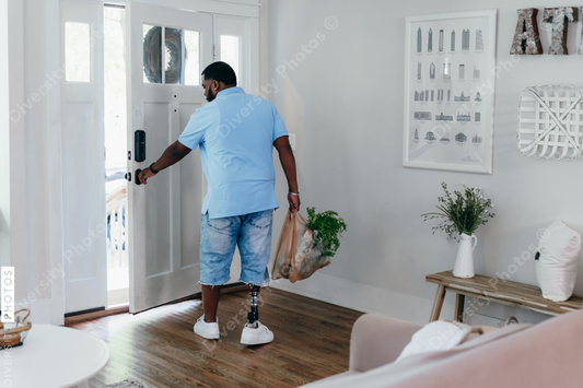 Black man with prosthetic leg bringing home groceries