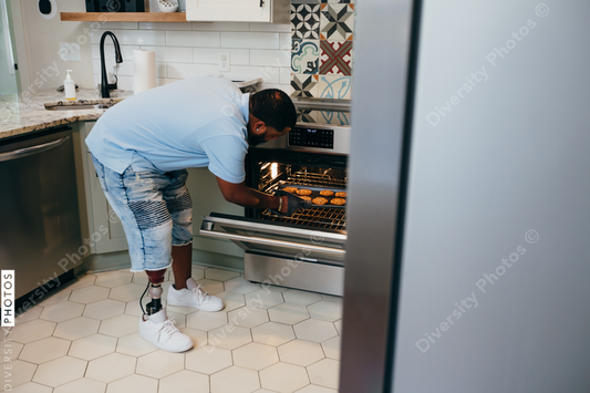Black man bakes cookies in kitchen, disabled