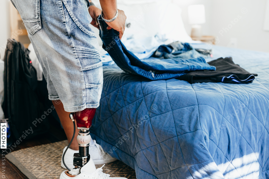 African American man with prosthetic leg doing chores, laundry, at home