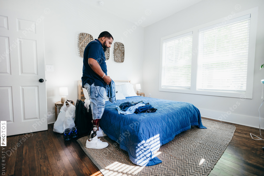 African American man with prosthetic leg doing chores, laundry, at home