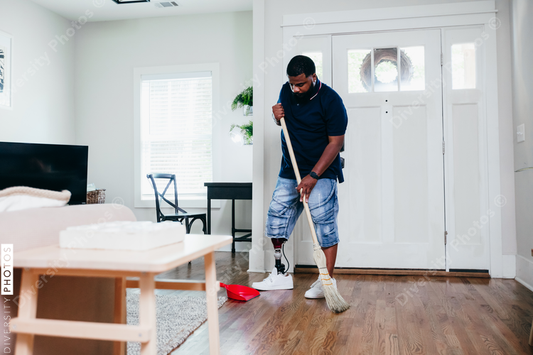 African American man doing chores around the house, sweeping, disabled