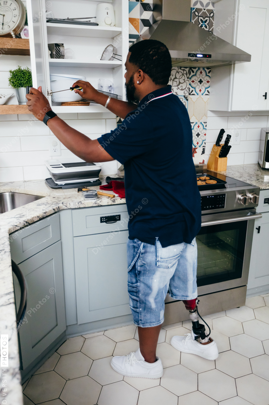 Black man with prosthetic leg DIY, repairing things around the house