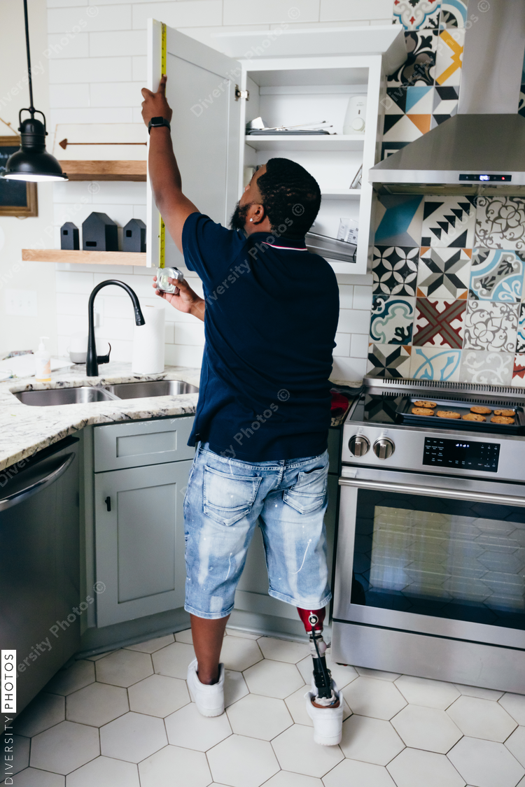 Black man with prosthetic leg DIY, repairing things around the house