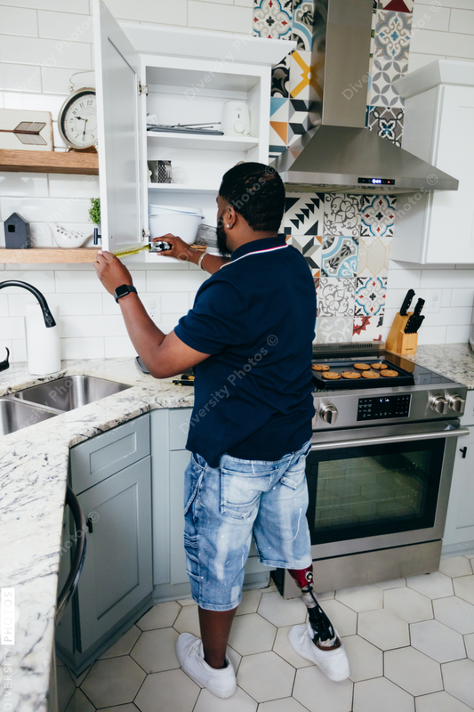 Black man with prosthetic leg DIY, repairing things around the house