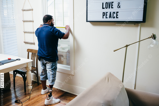 Black man with prosthetic leg DIY, repairing things around the house