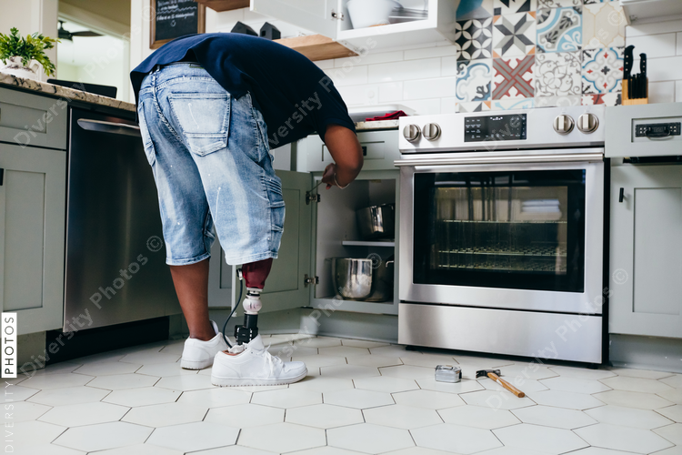Black man with prosthetic leg DIY, repairing things around the house
