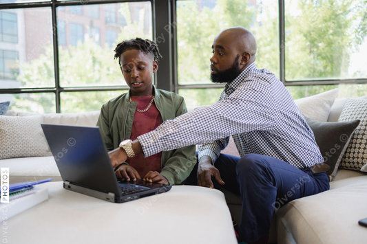 Black dad helps son do homework 