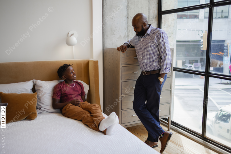 Father and son talking in bedroom