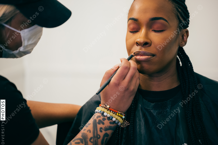 Black woman getting makeup on face