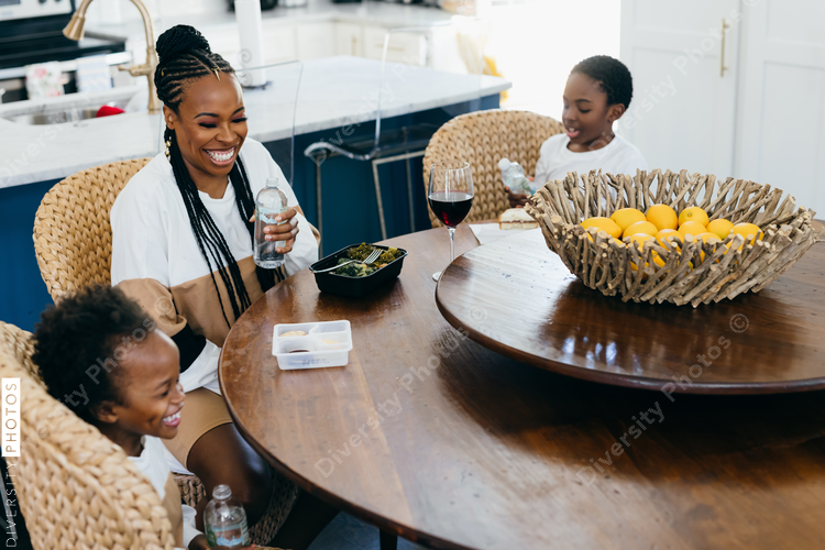 Black stay at home mother eats lunch with son and daughter