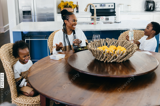 Black stay at home mother eats lunch with son and daughter