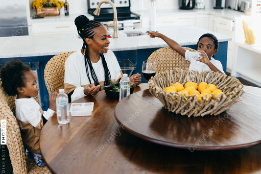 Black stay at home mother eats lunch with son and daughter