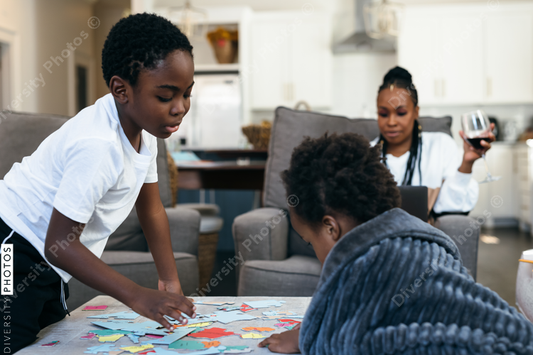 Black kids playing board games, puzzle, at home, while mom is working