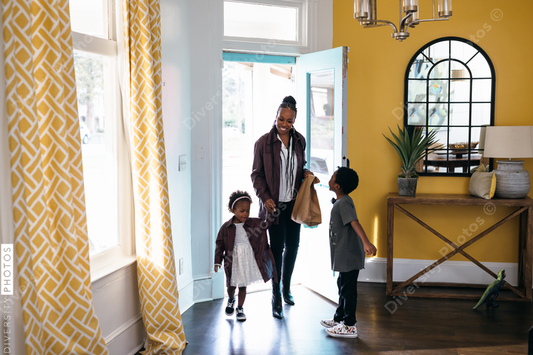 African American mother bringing in groceries with kids
