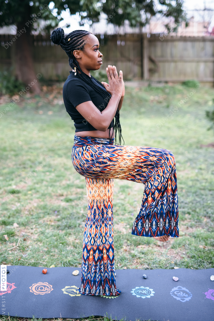 Black woman practicing yoga in backyard, healthy lifestyle