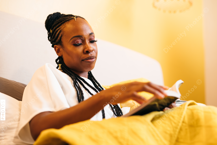 Woman reading novel book at home, evening 