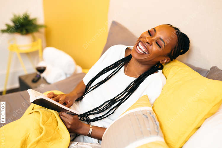 Happy Black woman reading book and smiling