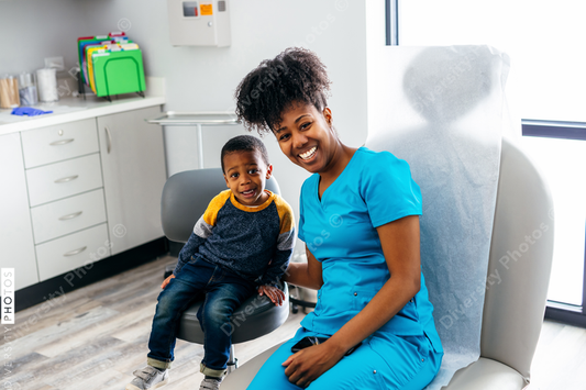 Young child posing with nurse in medical exam room