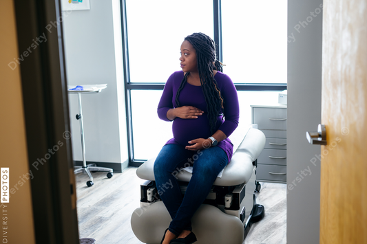 Black pregnant woman waiting in medical exam room at the Doctors office