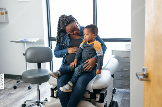 Black mom and toddler waiting in medical exam room