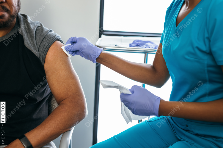 Black senior man gets vaccine, from nurse at doctors office