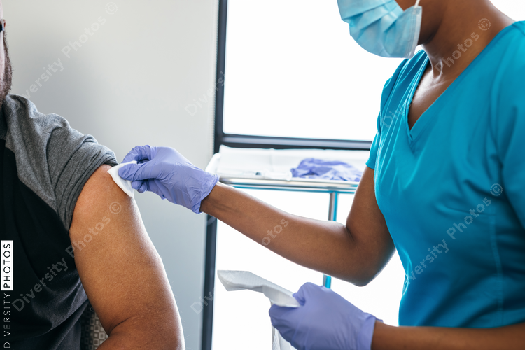 Black senior man gets vaccine, from nurse at doctors office