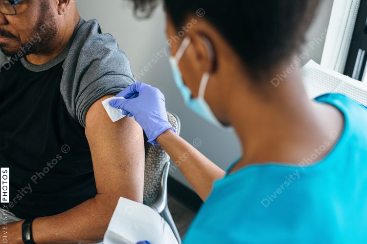 Black senior man gets vaccine, from nurse at doctors office