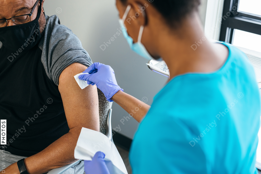 Black senior man gets vaccine, from nurse at doctors office