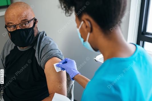 Black senior man gets vaccine, from nurse at doctors office