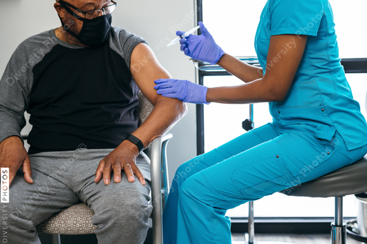 Black senior man gets vaccine, from nurse at doctors office