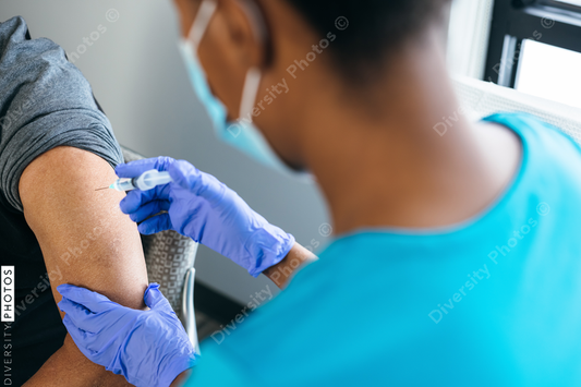Black senior man gets vaccine, from nurse at doctors office